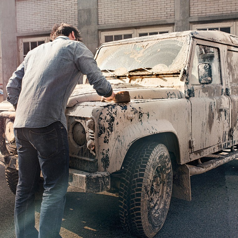 Muž čistí špinavé auto Muž čistí špinavé auto