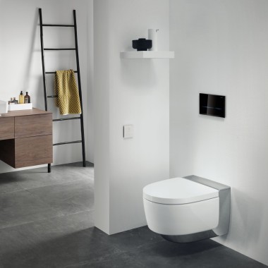 Dvě světelné lišty černé bezdotykové spouštěcí desky Geberit Sigma80 dodávají černobílému designu koupelny barevný akcent. Vyberte si jednu z pěti barev. Sprchové WC Geberit AquaClean Mera poskytuje větší komfort v koupelně.
