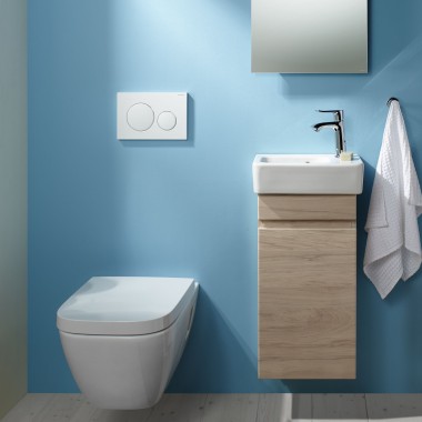Závěsné WC Selnova a prostor s umyvadlem na světle modré stěně.