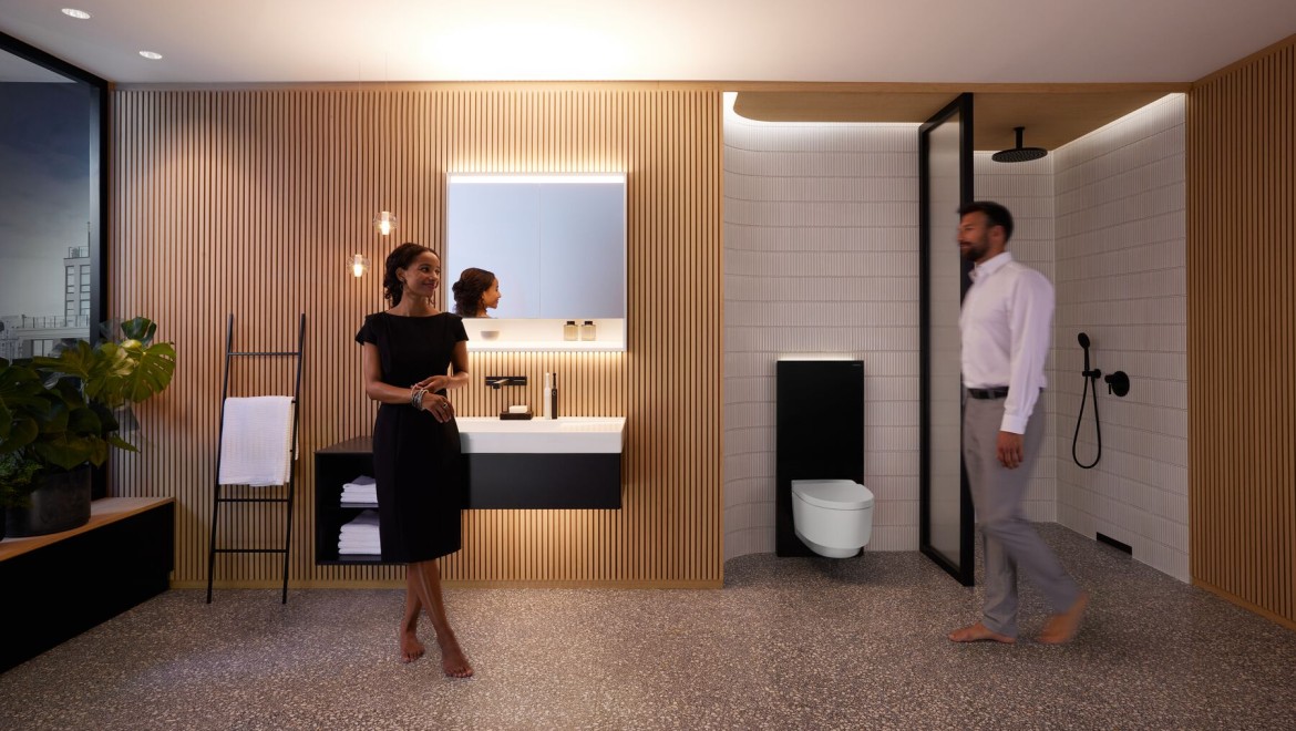 Muž a žena v dokonale osvětlené koupelně s výrobky Geberit ONE