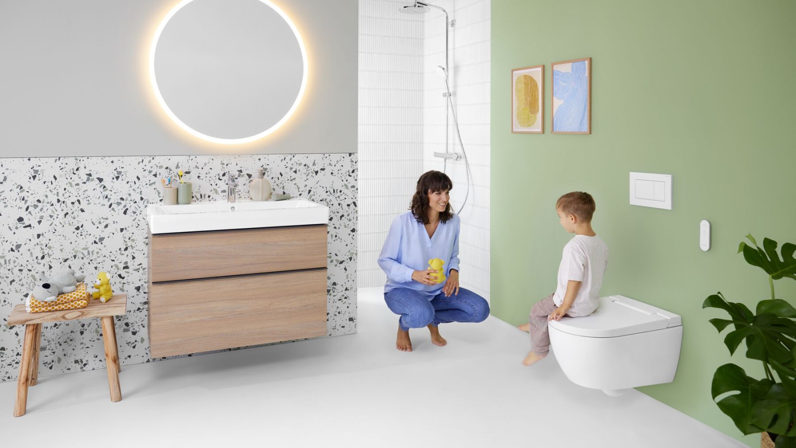 Žena a dítě v koupelně se sprchovacím WC Geberit AquaClean Alba Žena a dítě v koupelně se sprchovacím WC Geberit AquaClean Alba