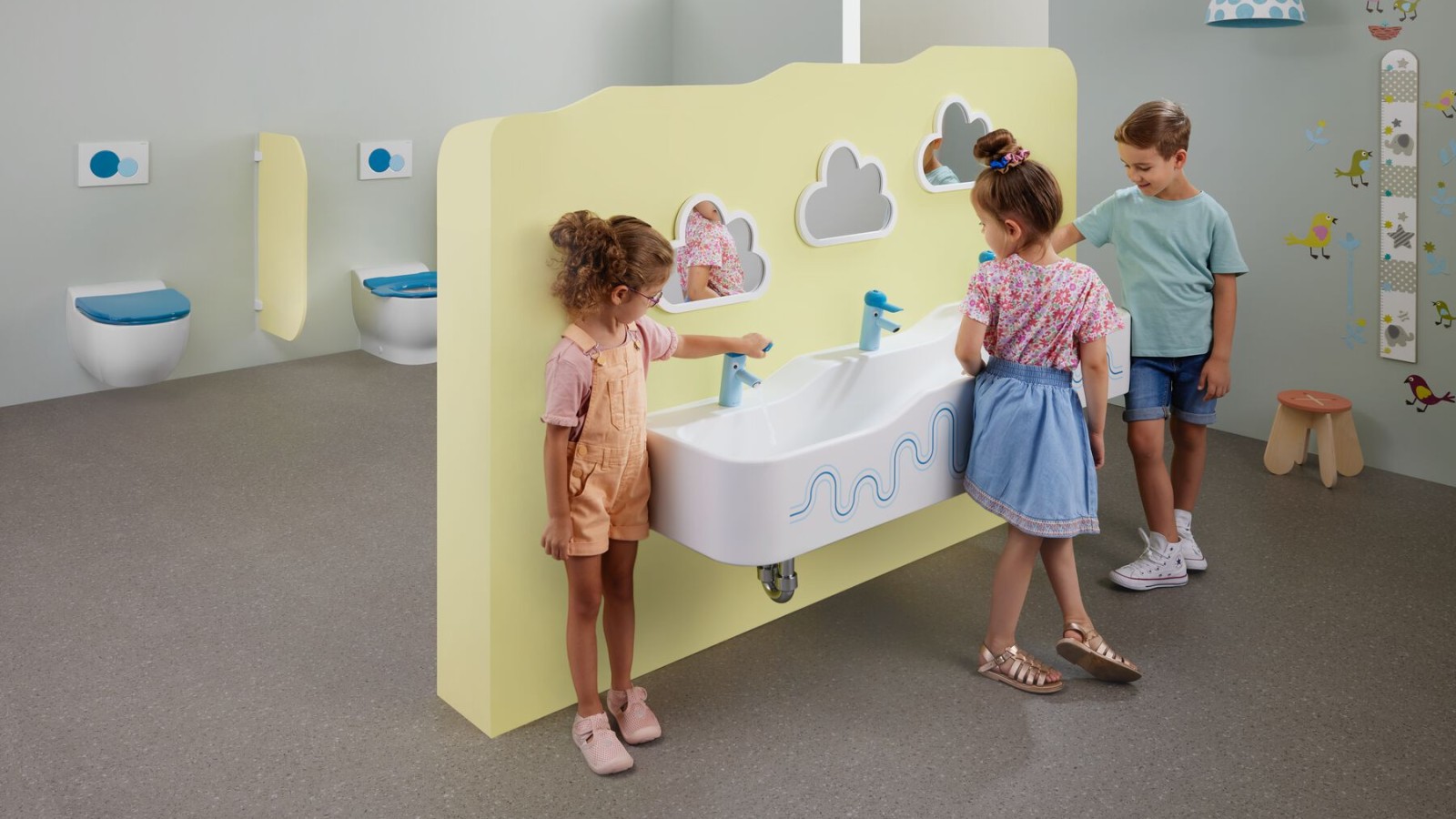 Děti si hrají v sanitární místnosti vybavené systémem Geberit Bambini Děti si hrají v sanitární místnosti vybavené systémem Geberit Bambini