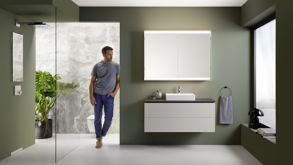 Muž stojící v koupelně s koupelnovou sérií Geberit ONE