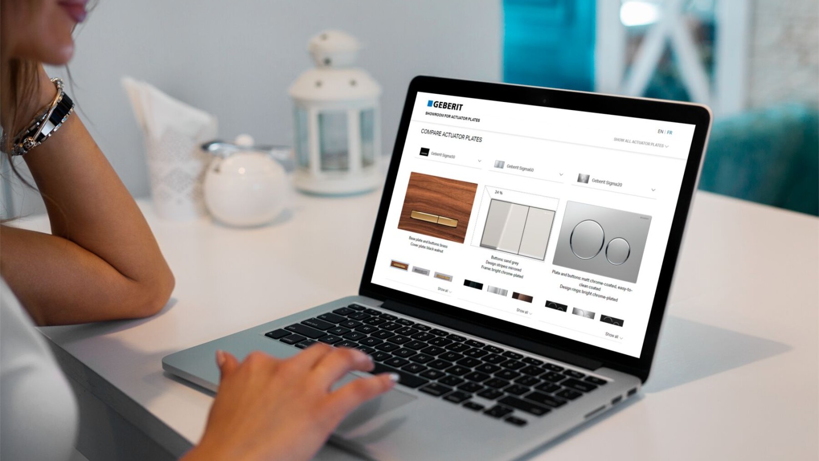 Žena spouští na notebooku showroom s ovládacími tlačítky Geberit Žena spouští na notebooku showroom s ovládacími tlačítky Geberit