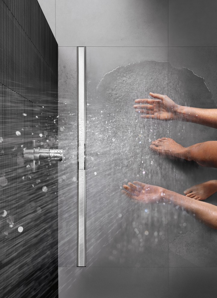 Osoba sprchující se ve sprše na úrovni podlahy vybavené sprchovým kanálkem Geberit CleanLine
