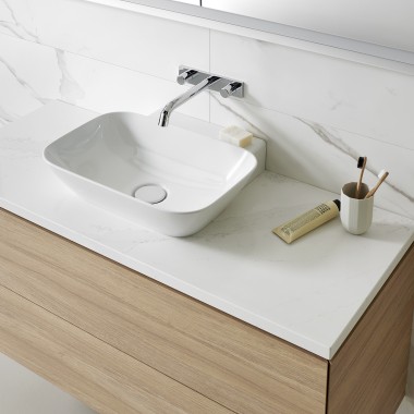 Umyvadlo s bílými keramickými spotřebiči a koupelnovým nábytkem ze dřeva (© Geberit)