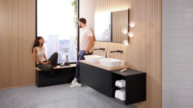 Žena a muž ve velké koupelně s umyvadly na desku Geberit ONE, se zrcadlem Option a dřevěnými prvky