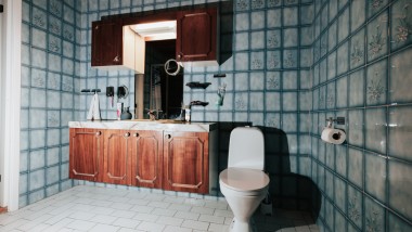 Koupelna s modrými obklady a stojícím WC