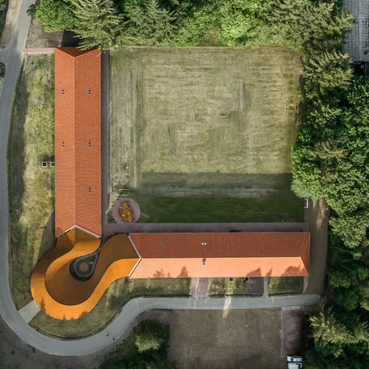 Pohled shora ukazuje kruhovou novostavbu, která spojuje obě historické budovy s taškovými střechami. (© R_Hjortshoj) Pohled shora ukazuje kruhovou novostavbu, která spojuje obě historické budovy s taškovými střechami. (© R_Hjortshoj)